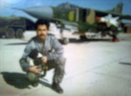 A pilot of the Libyan 1090th Air Squadron and his MiG-23MF Flogger-B fighter jet at the Ghardabiya air base in the 1980s. The MiG-23MF has an unusual dark camouflage pattern for the desert, similar to that of the Czechoslovak MiG-23MFs. It was armed with R-3S Atoll and R-23R Apex missiles.